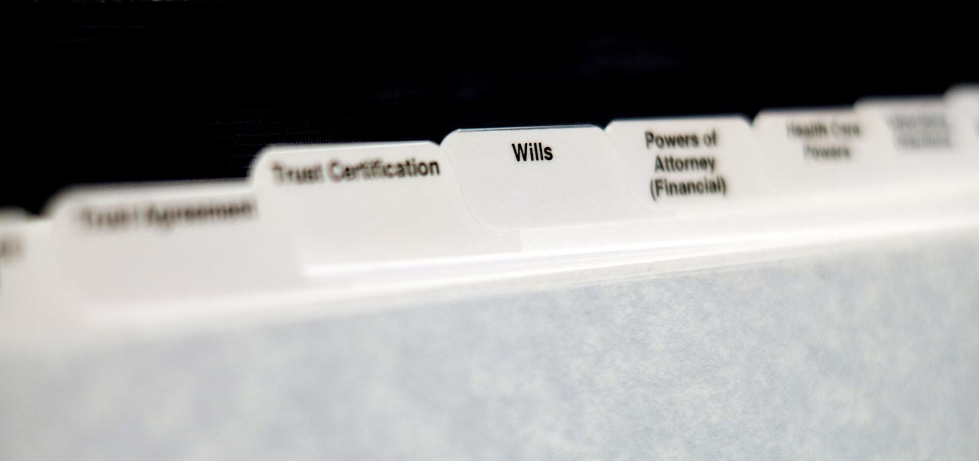 Estate planning documents organized with tabs for Will Power of Attorney and Trust